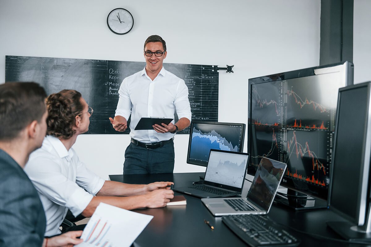 a man standing in front of a group of people working on computers